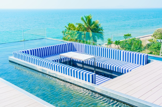 terraza-con-sillones-azules-y-blancos-y-una-piscina-alrededor_1203-2078